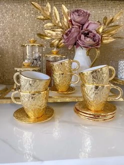 Gold Textured Metal Tea Cup And Saucer With White Interior